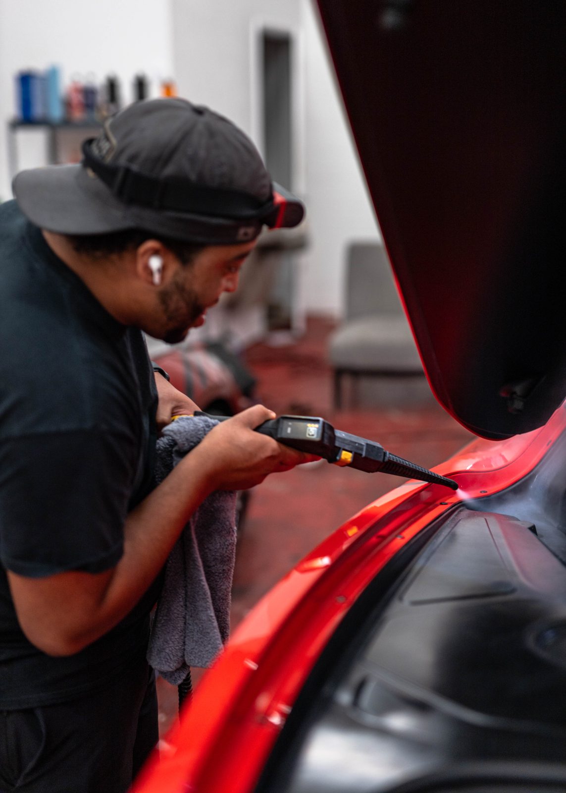 Obsidian detailer machine-polishing a car in the bay near Durham