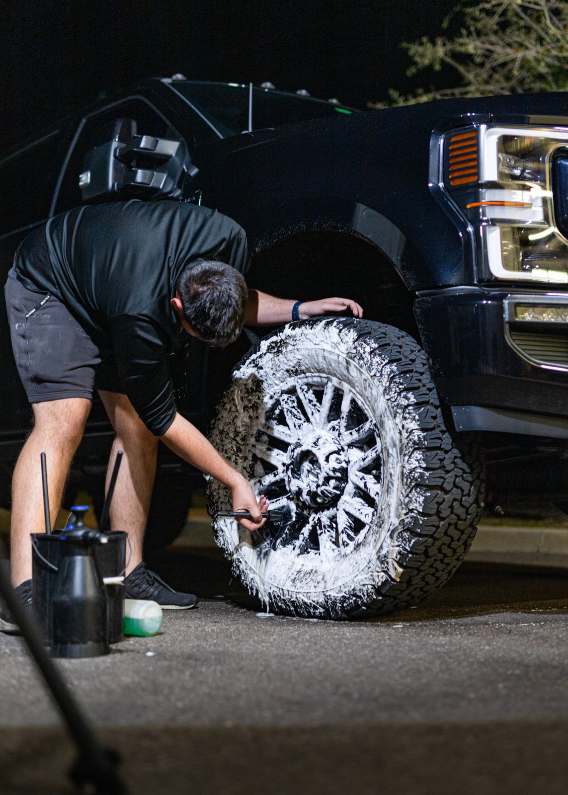 Obsidian detailer polishing a truck wheel at a Hillsborough driveway